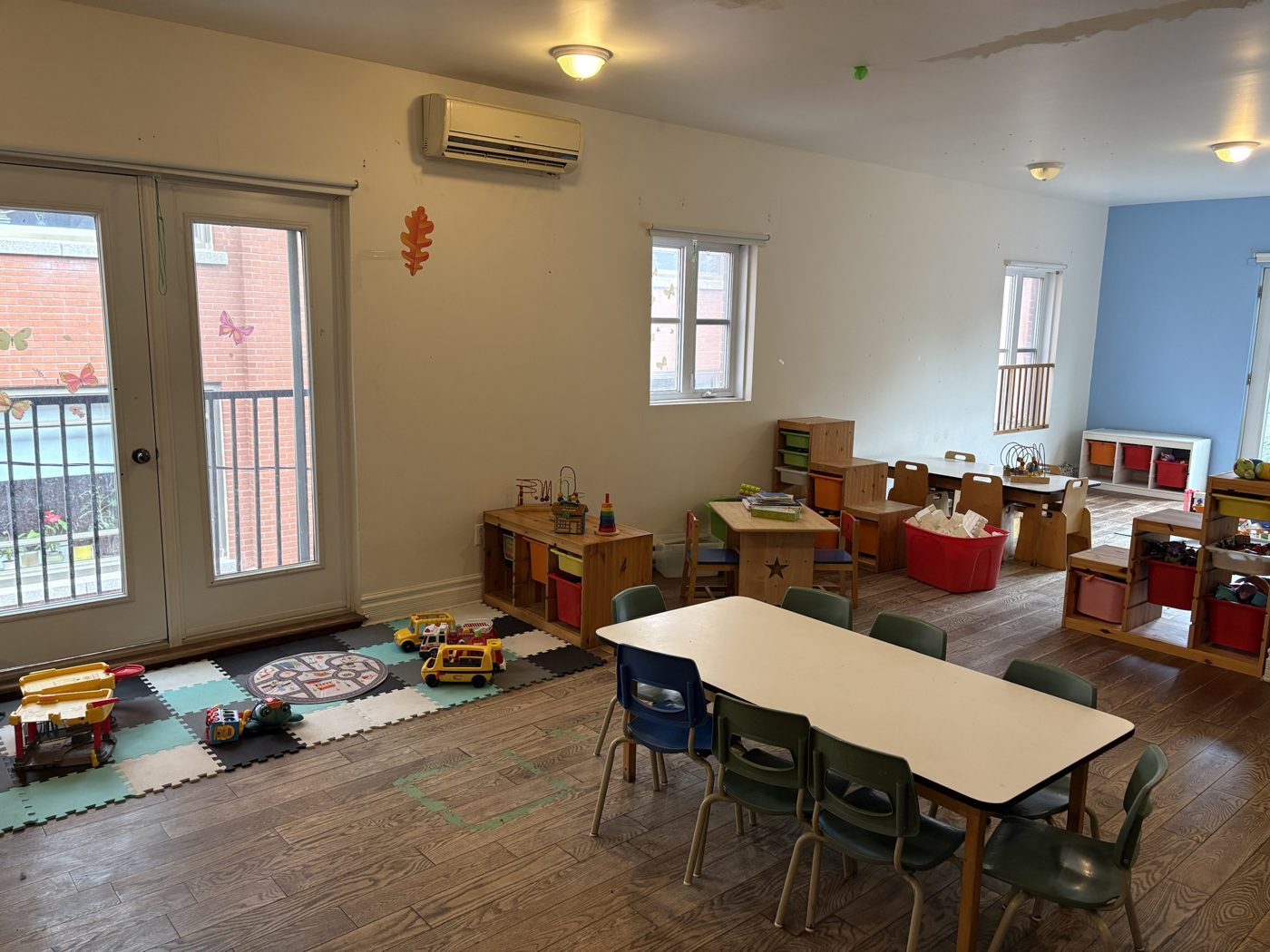 Salle de jeu avec tapis de circuit routier et mobilier en bois